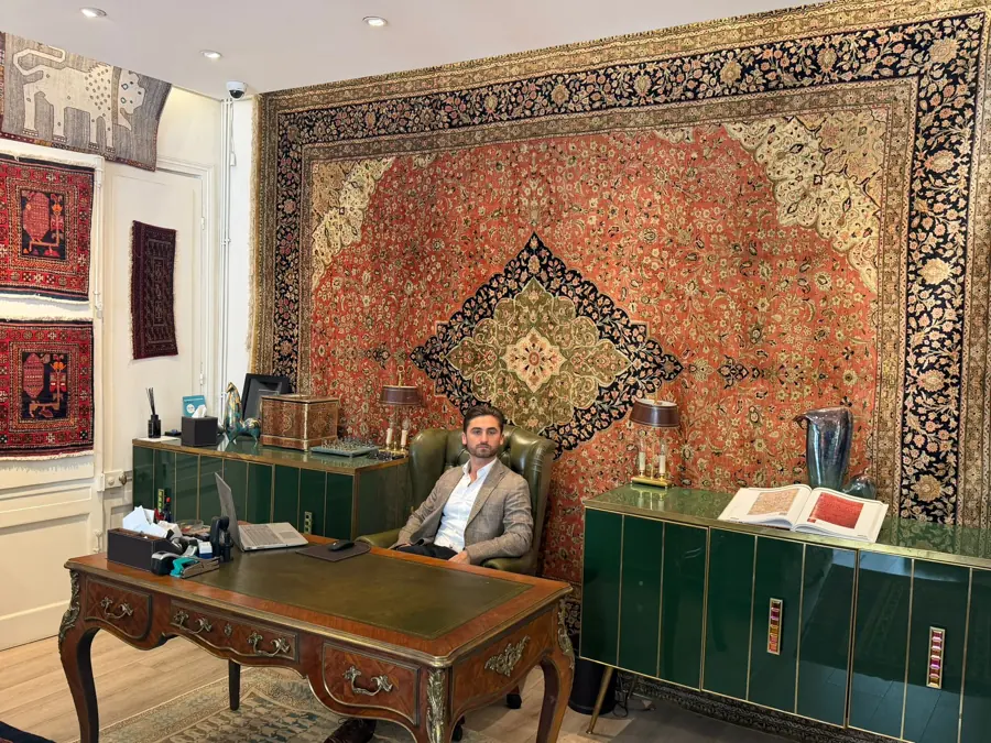 Le responsable de Babylone Tapis Orient dans la galerie de Metz